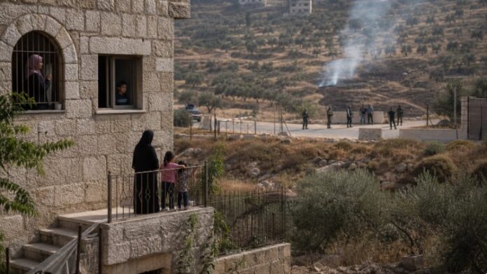 قُصرہ میں فلسطینی گھر کے قریب فوجی رکاوٹ اور زرعی زمین سے اٹھتا دھواں